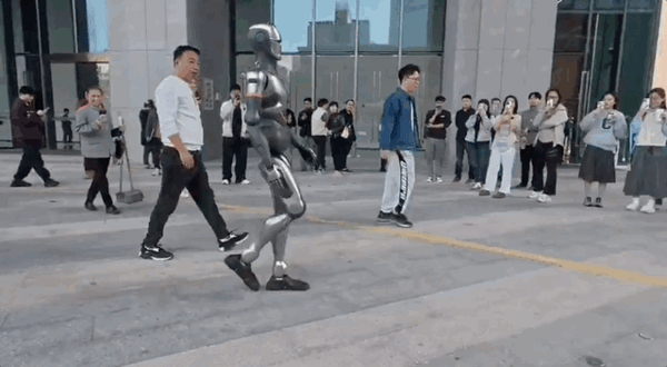 国产人形机器人街边溜达爆火海外:自然步态大步流星如模特T台秀